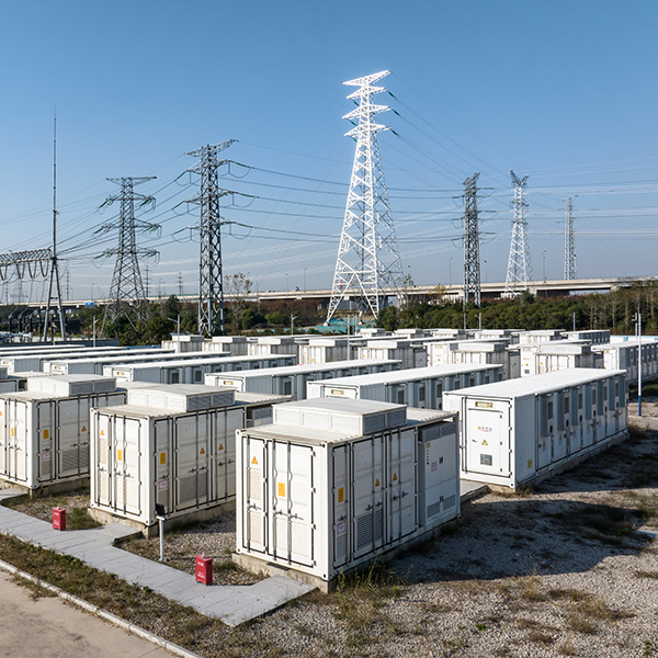 Battery storage containers beneath transmission towers